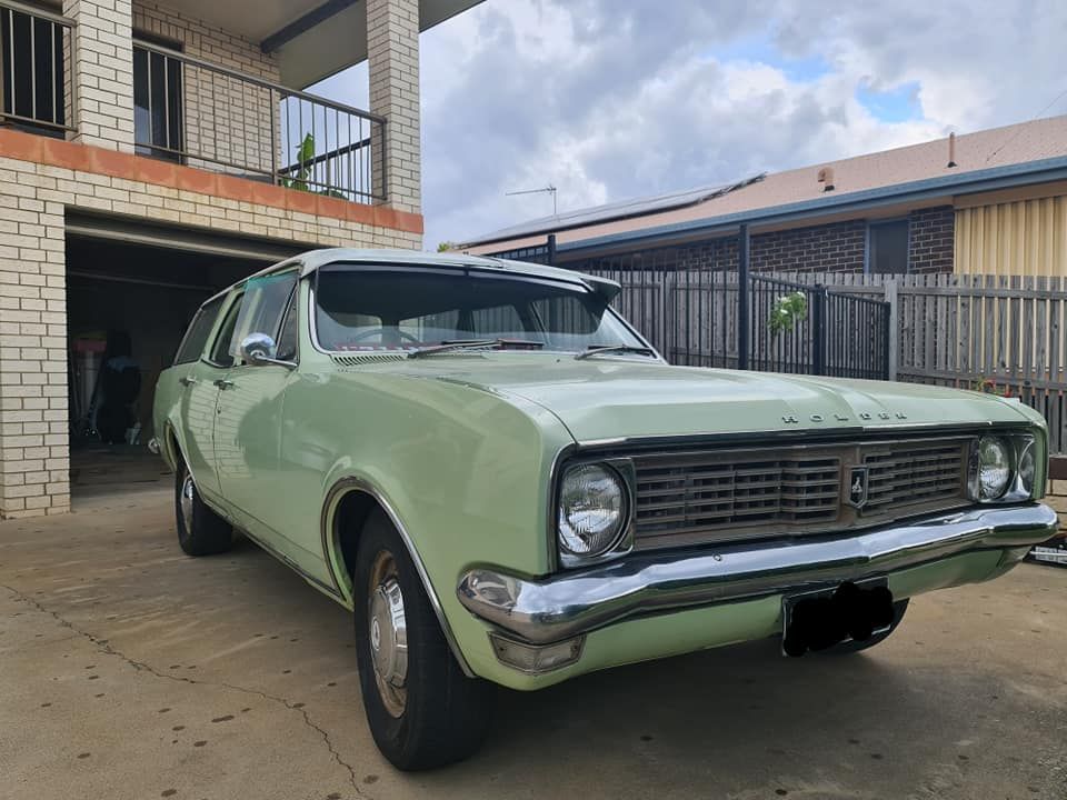 A Green Car Is Parked In Front Of A Brick Building — M8S Rates Mechanical In Gladstone Central, QLD