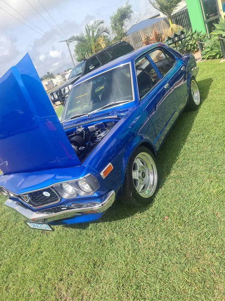 A Blue Car With The Hood Up Is Parked In The Grass — M8S Rates Mechanical In Gladstone Central, QLD