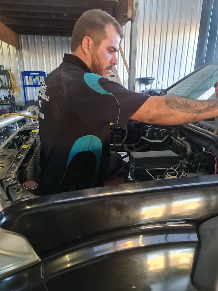 A Man Is Working On The Engine Of A Car In A Garage — M8S Rates Mechanical In Gladstone Central, QLD