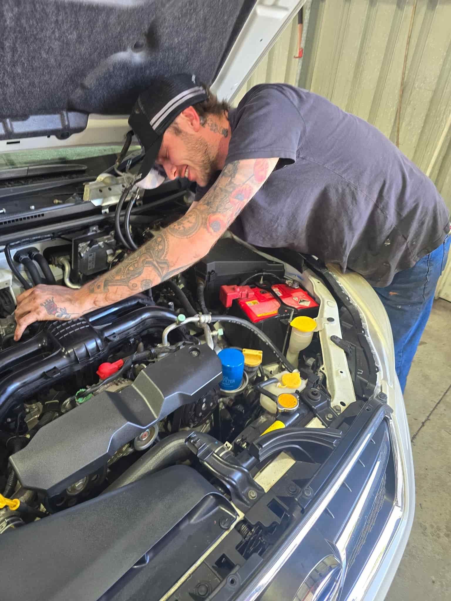 A Man Is Looking Under The Hood Of A Car — M8S Rates Mechanical In Gladstone Central, QLD