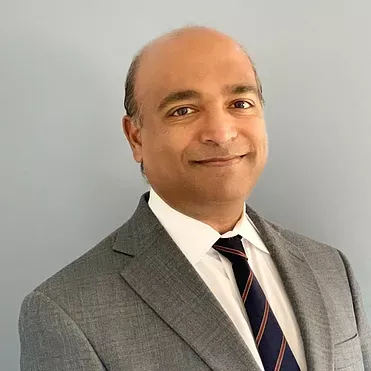 A man in a suit and tie is smiling for the camera.