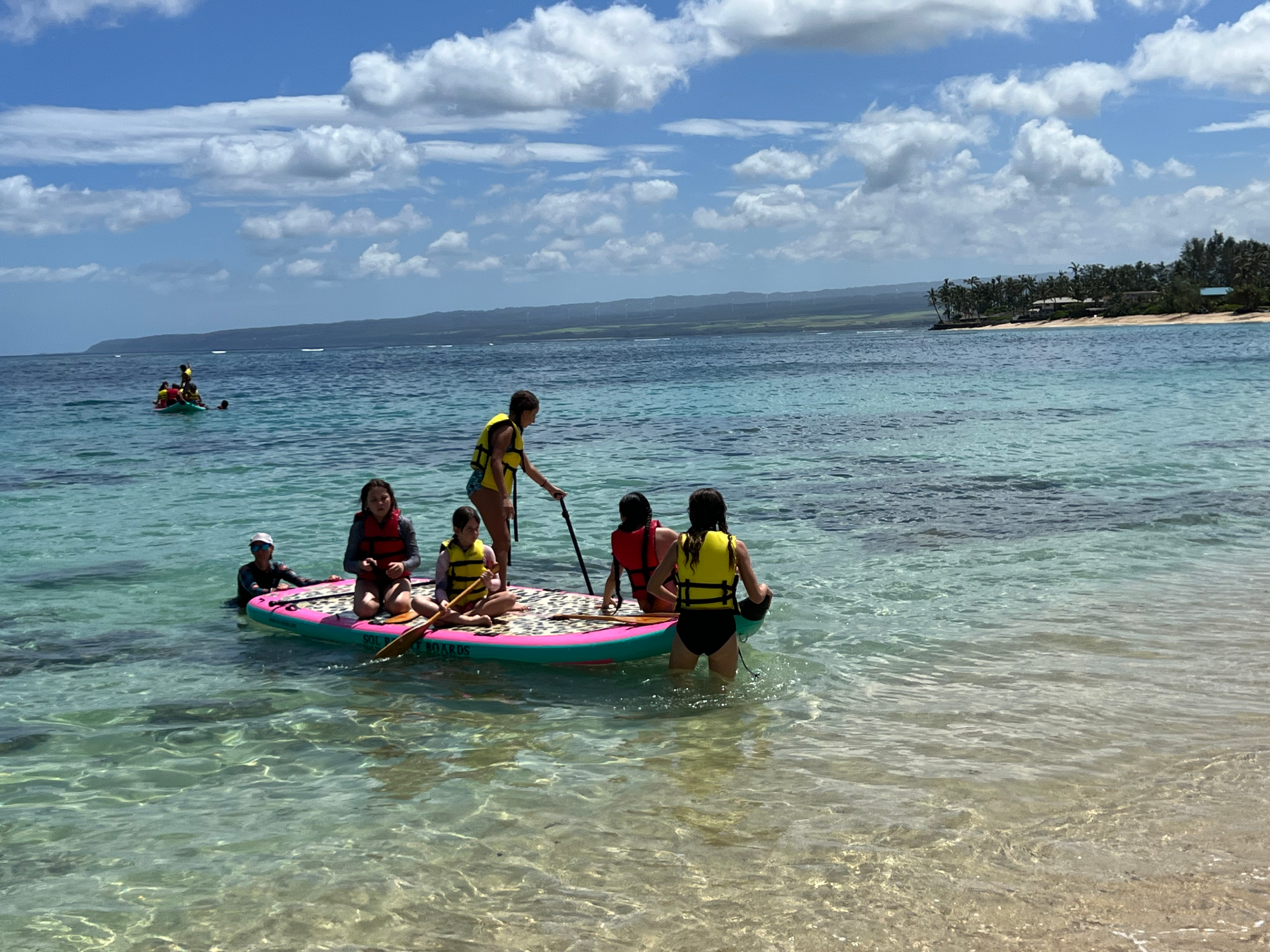 A group of people are riding rafts in the ocean.