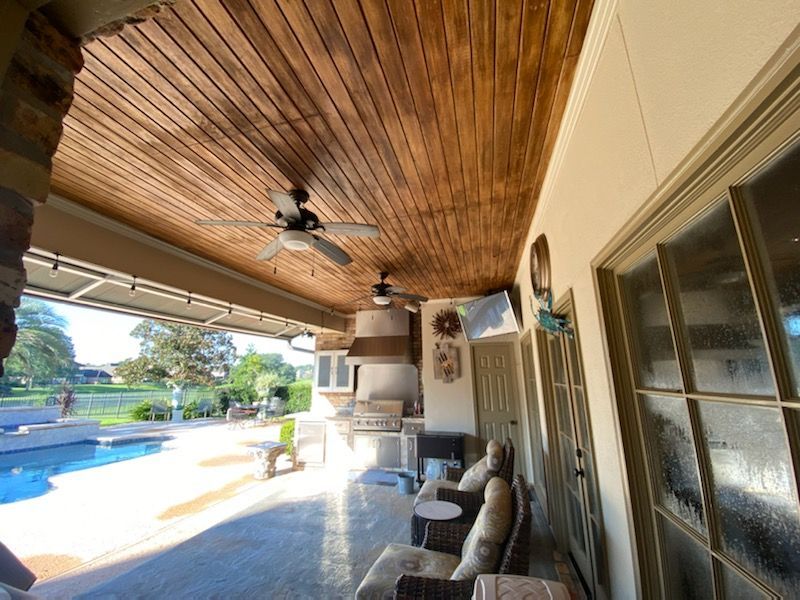 A patio with a wooden ceiling and a ceiling fan. A patio with a wooden ceiling and a ceiling fan.