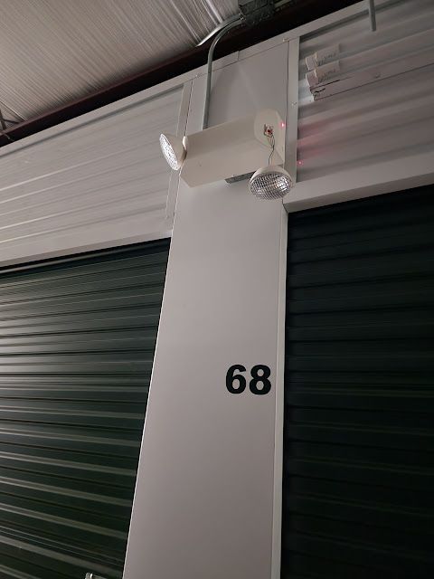 A light on the side of a building with the number 68 on it. A light on the side of a building with the number 68 on it.