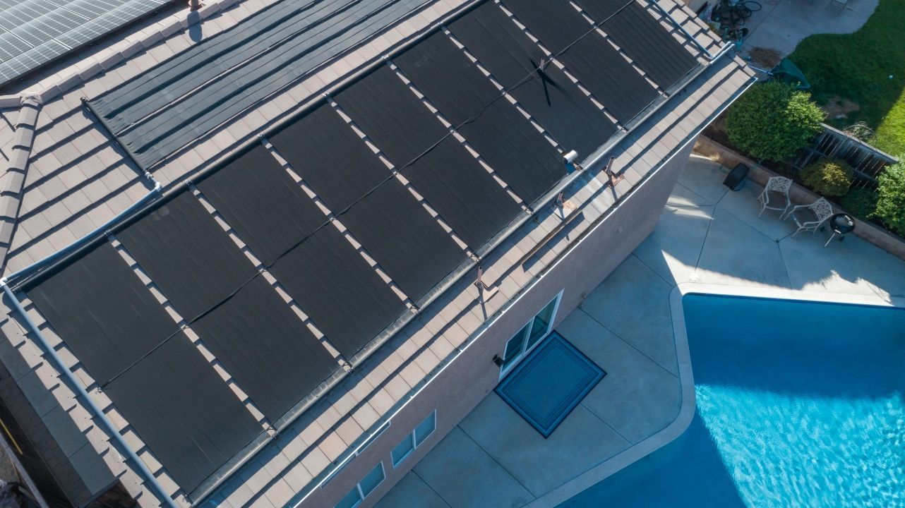 Solar Panels on a House Roof With Pool in the Background — Tempshift Pool Heating in Gosford, NSW