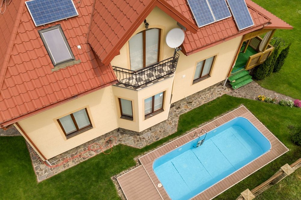 House With Solar Panels, Balcony, and Pool Surrounded by Green Grass — Tempshift Pool Heating in Hunter Valley, NSW