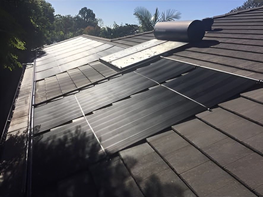Solar panels installed on a tiled roof under a sunny, blue sky — Tempshift Pool Heating in Gosford, NSW