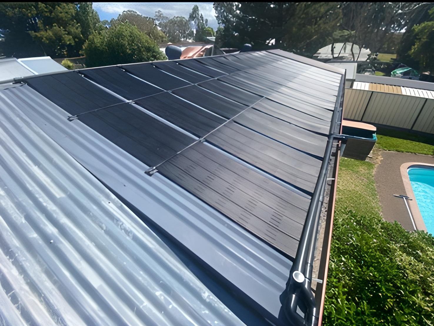 Solar Panels on a Corrugated Metal Roof Next to a Swimming Pool — Tempshift Pool Heating in Hunter Valley, NSW