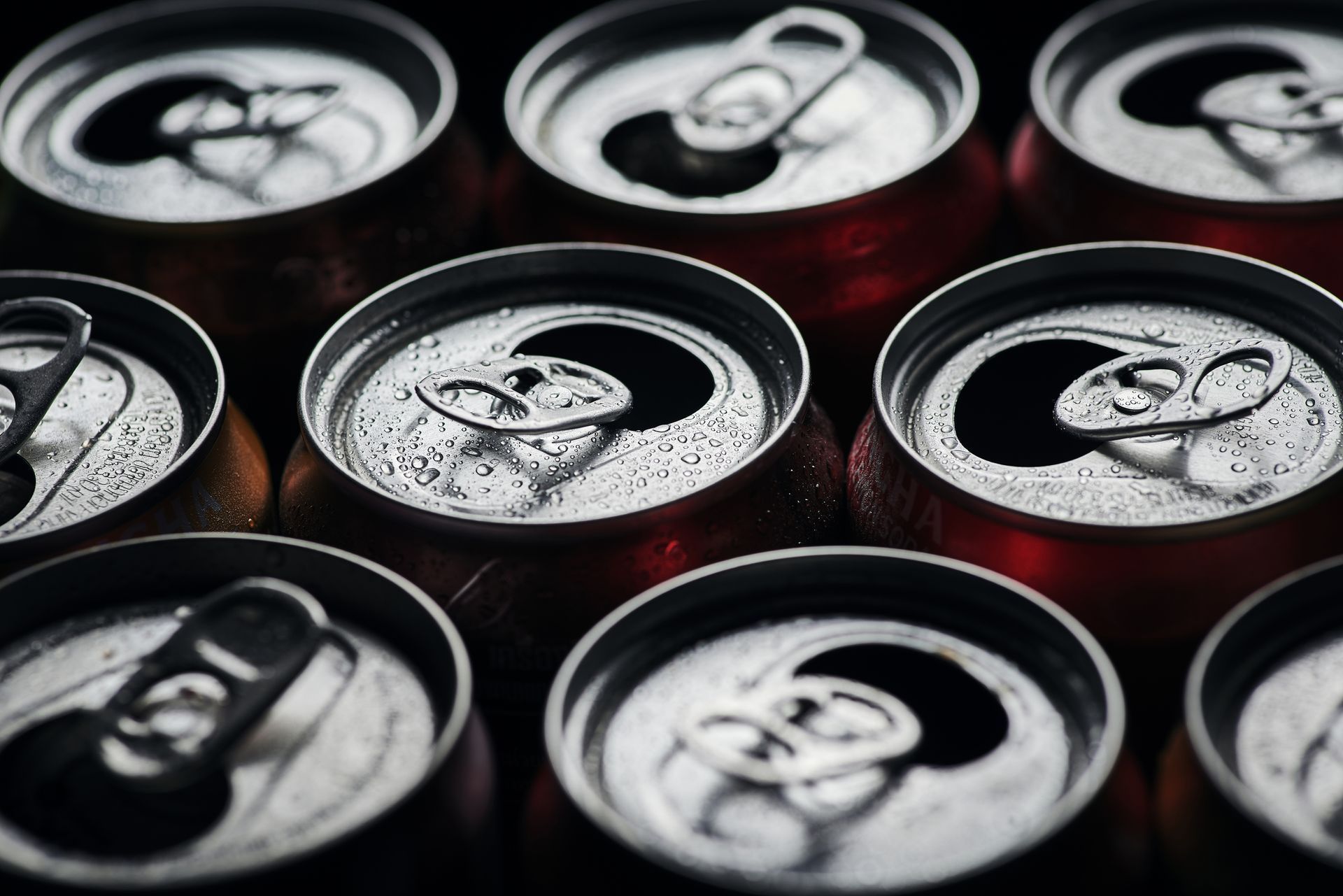 A bunch of soda cans are stacked on top of each other.