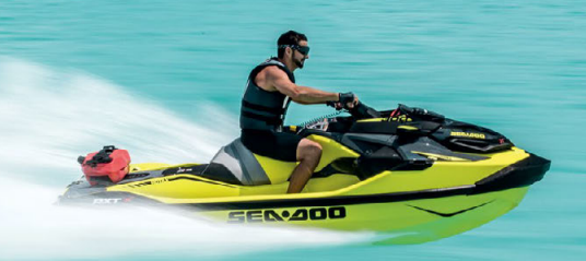 Una persona a bordo di una Sea-Doo gialla su acque turchesi, creando una scia bianca.
