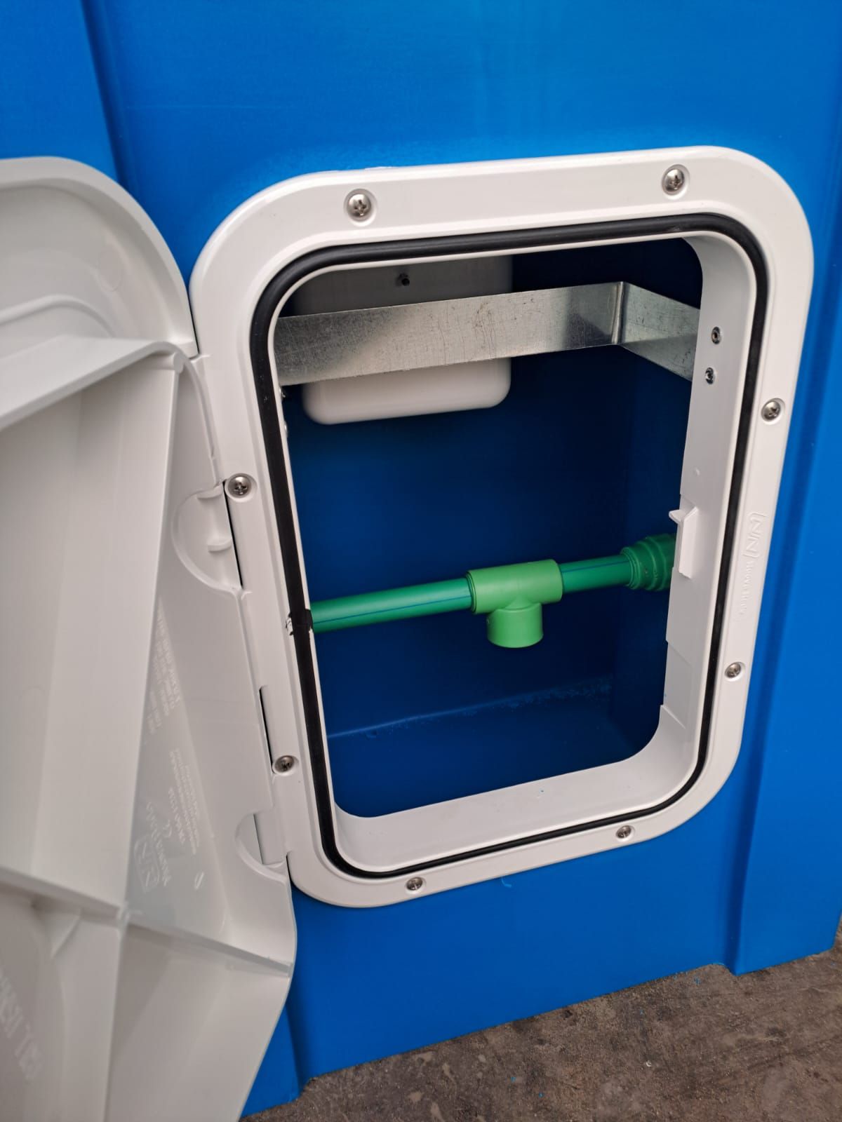 Contenitore blu con sportello bianco aperto, che rivela un tubo verde e componenti interni.