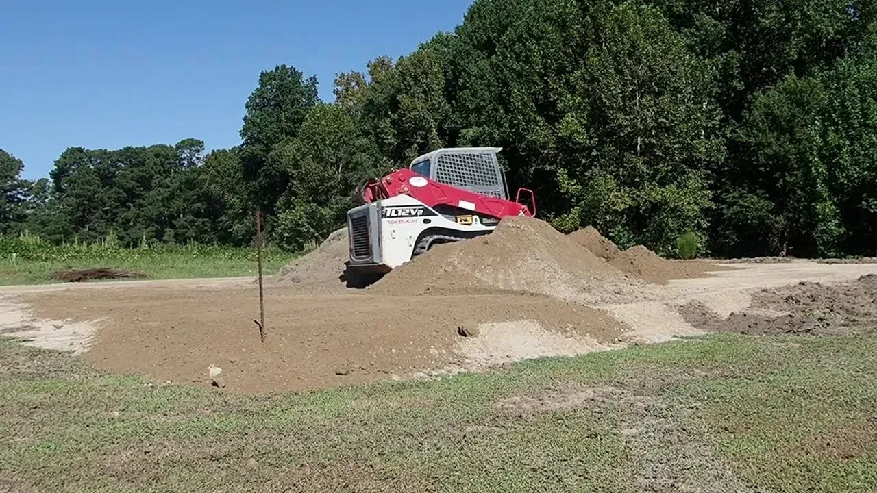 Track loader spreading fill dirt on a house pad project in Louisiana.