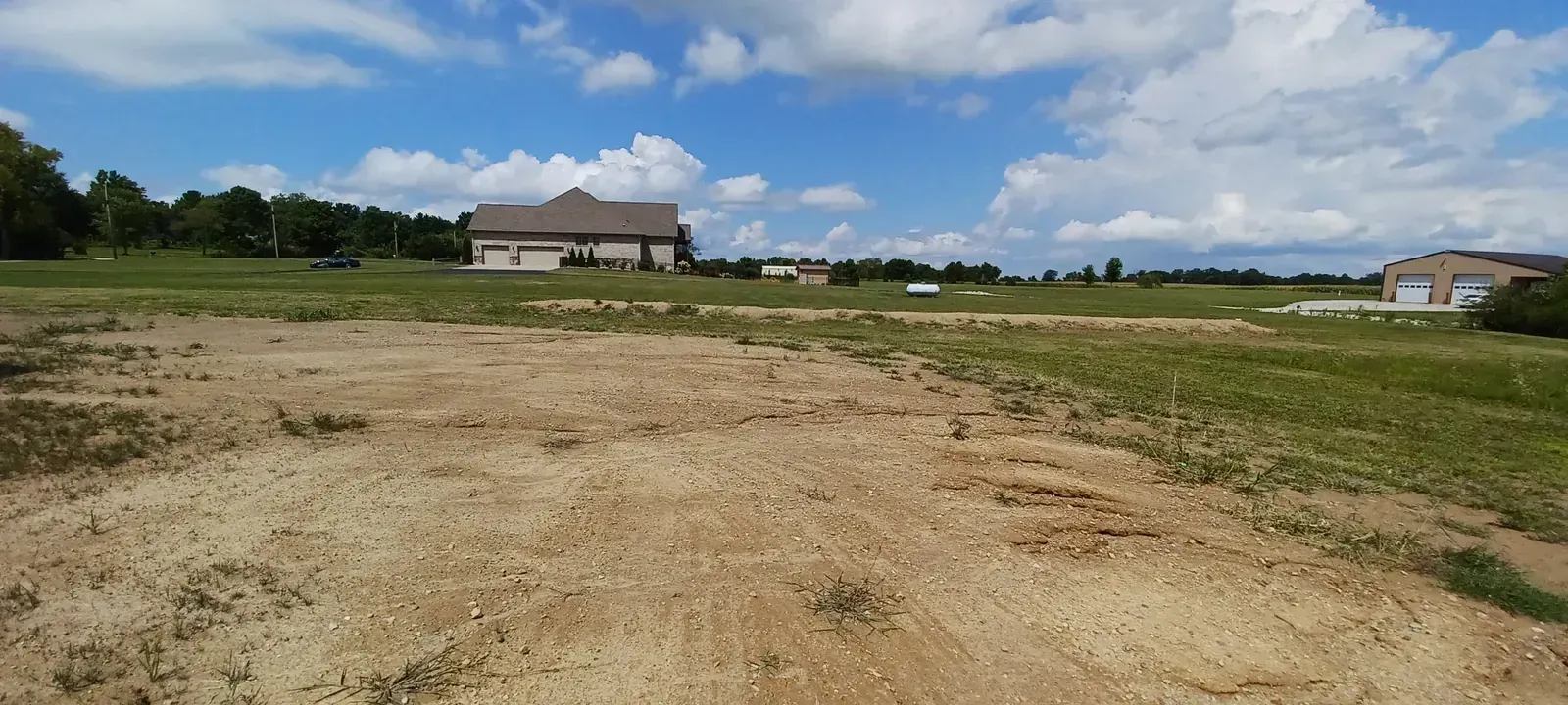 Graded residential lot with leveled dirt ground in front of a house in New Iberia, LA.