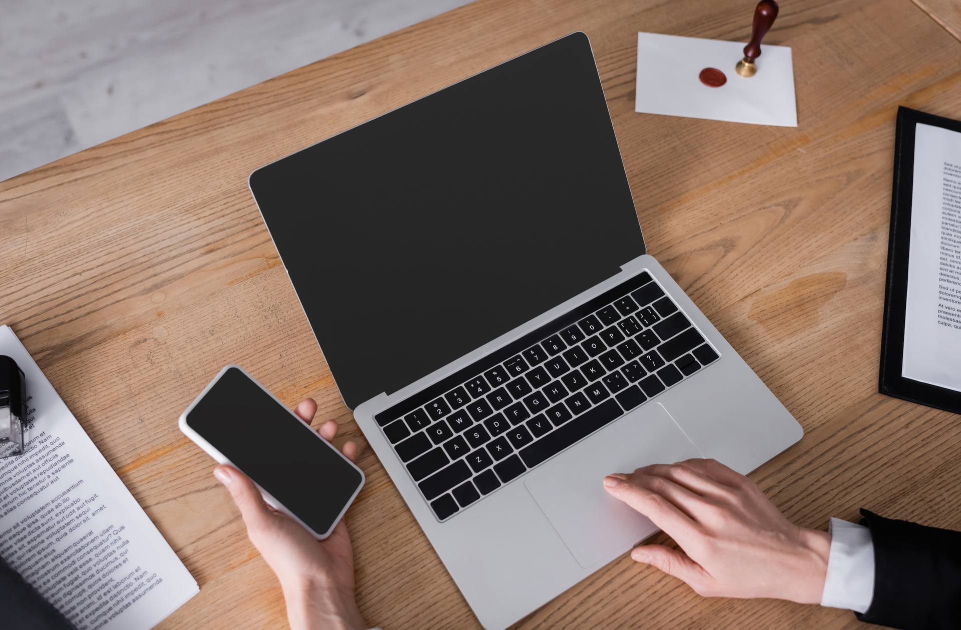 A woman is sitting at a desk in front of a laptop computer.
