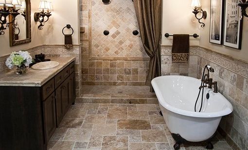 Luxurious bathroom with freestanding tub, double vanity, tiled shower wall, and wall sconces