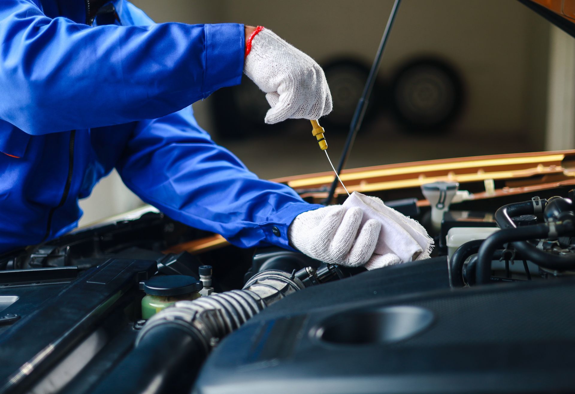 Mechanic checking oil level with dipstick during oil change