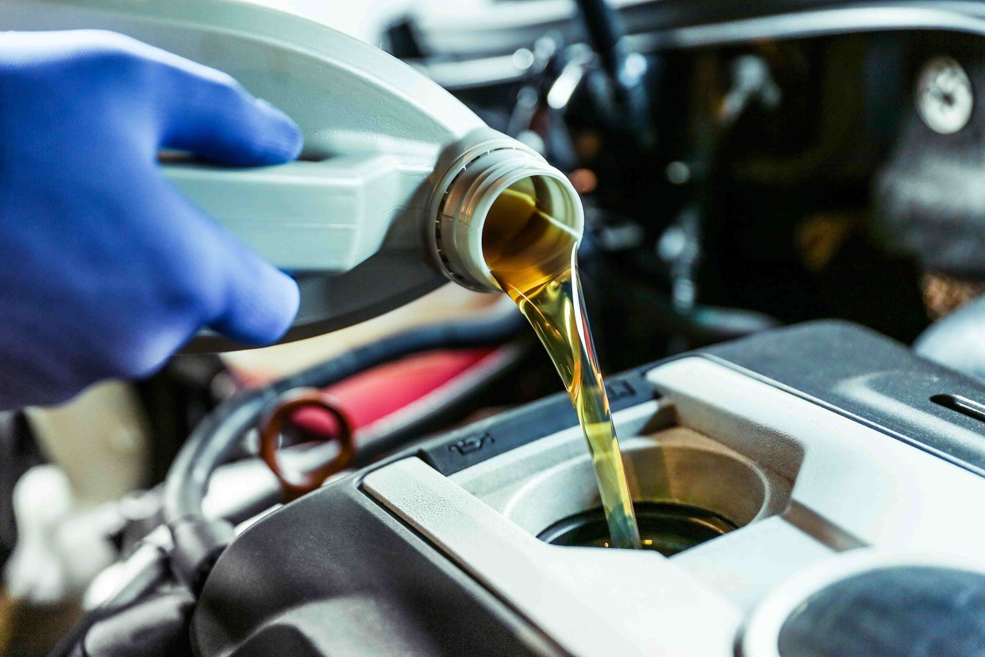 A mechanic is changing the oil of a car.