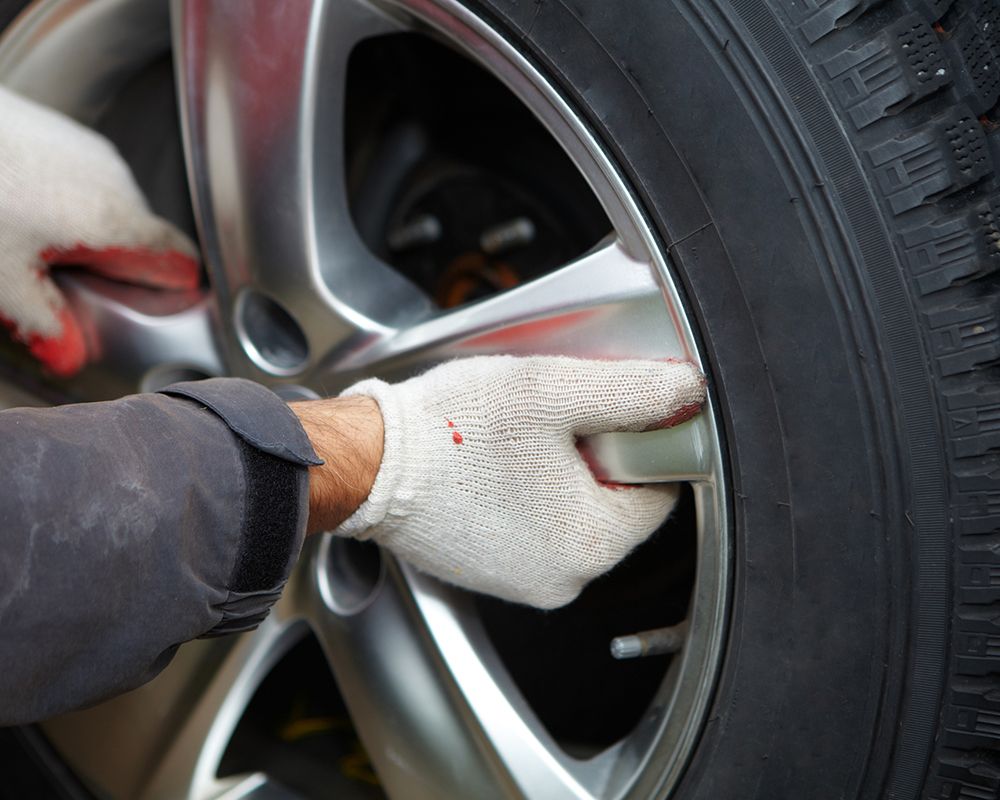 A mechanic from Professional Automotive changing a tire, showing expertise as a tire change provider
