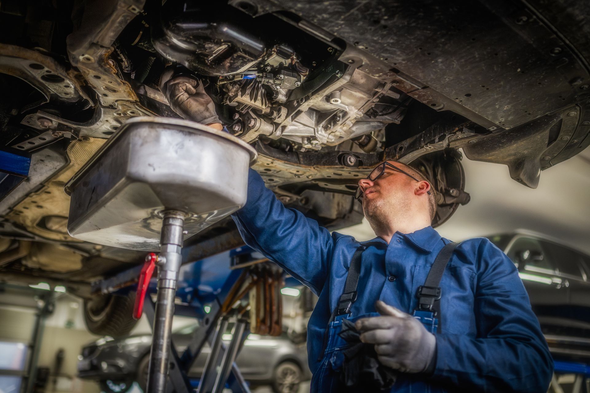 Car mechanic performing an oil change on a modern vehicle