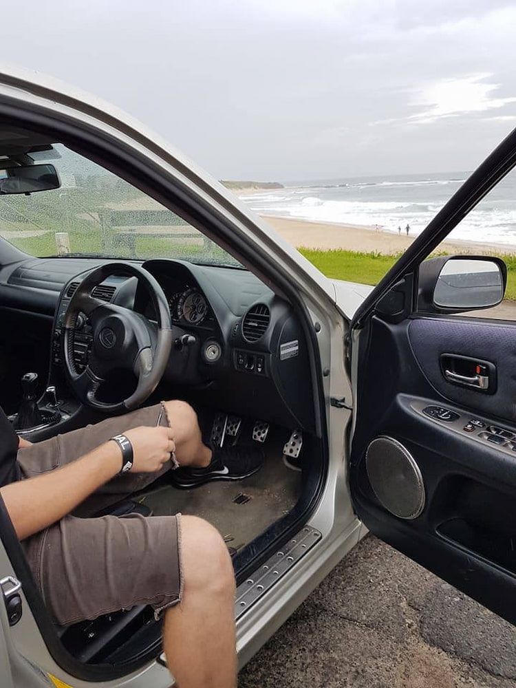 A Person is Sitting in the Driver 's Seat of a Car With the Door Open — South Coast Locksmiths in Warrawong, NSW