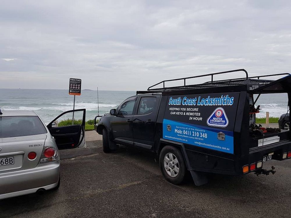 A Black Van is Parked in a Parking Lot Next to a Car — South Coast Locksmiths in Bulli, NSW