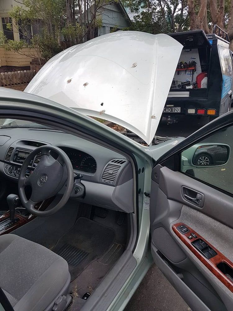 A Car With the Hood Open is Parked on the Side of the Road — South Coast Locksmiths in Shellharbour, NSW