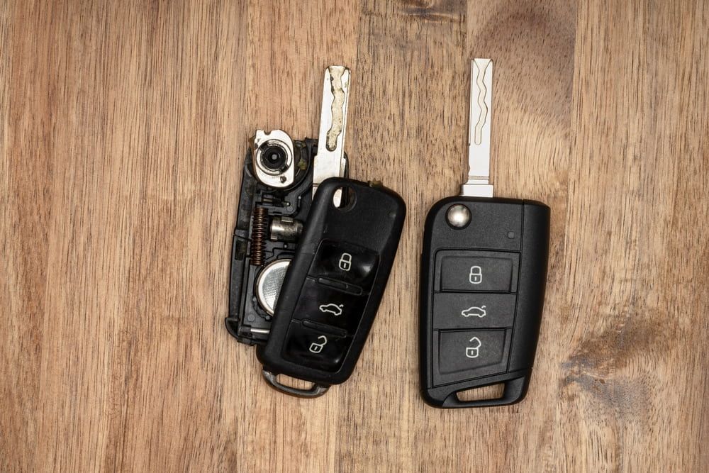 Two Car Keys Are Sitting on a Wooden Table — South Coast Locksmiths in Corrimal, NSW