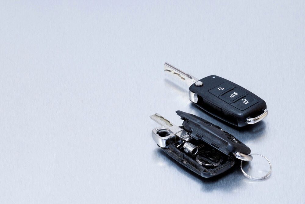 Two Car Keys Are Sitting on a Gray Surface — South Coast Locksmiths in Albion Park, NSW