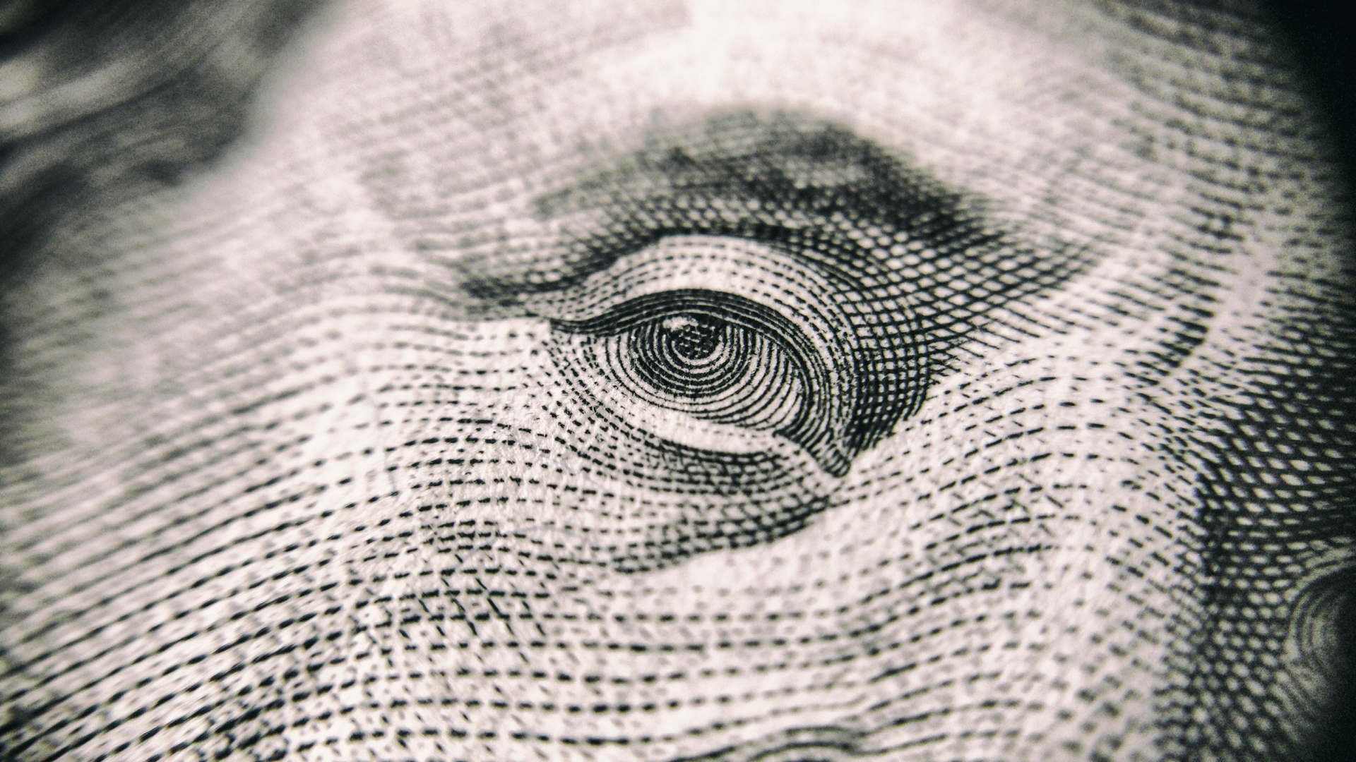 Close-up of an engraved eye on a U.S. dollar bill.