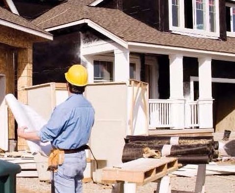 Engineer with blueprints at a project site