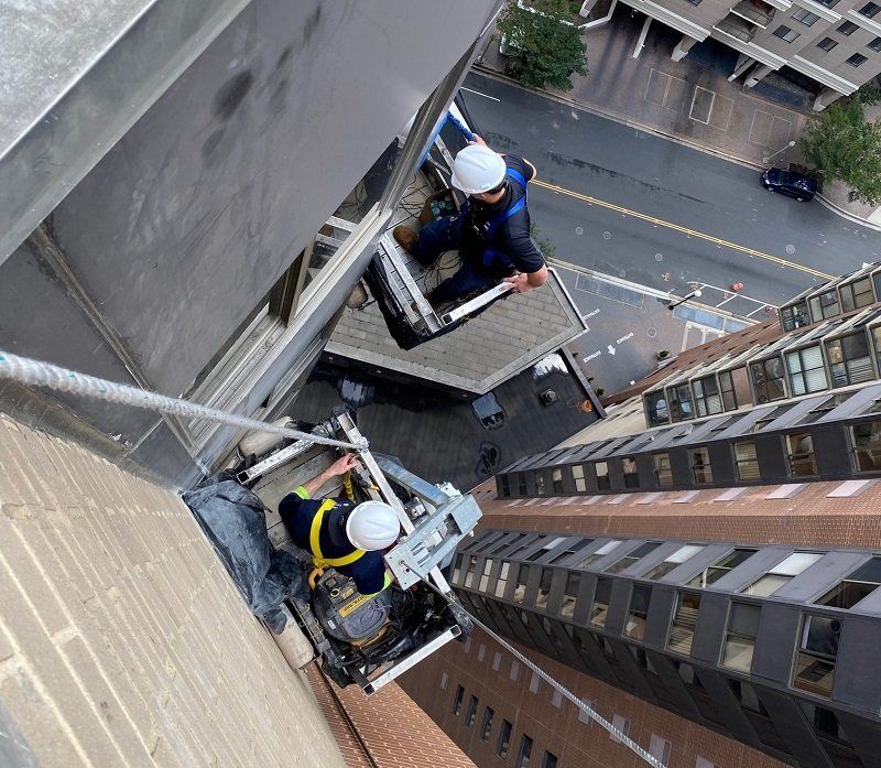 Workers on facade of building