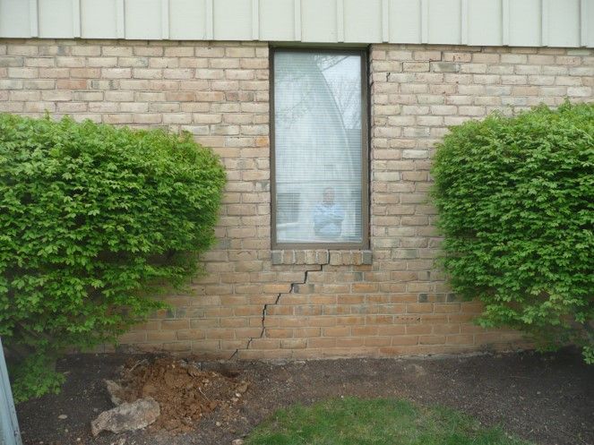 Crack going up the brick veneer of a building