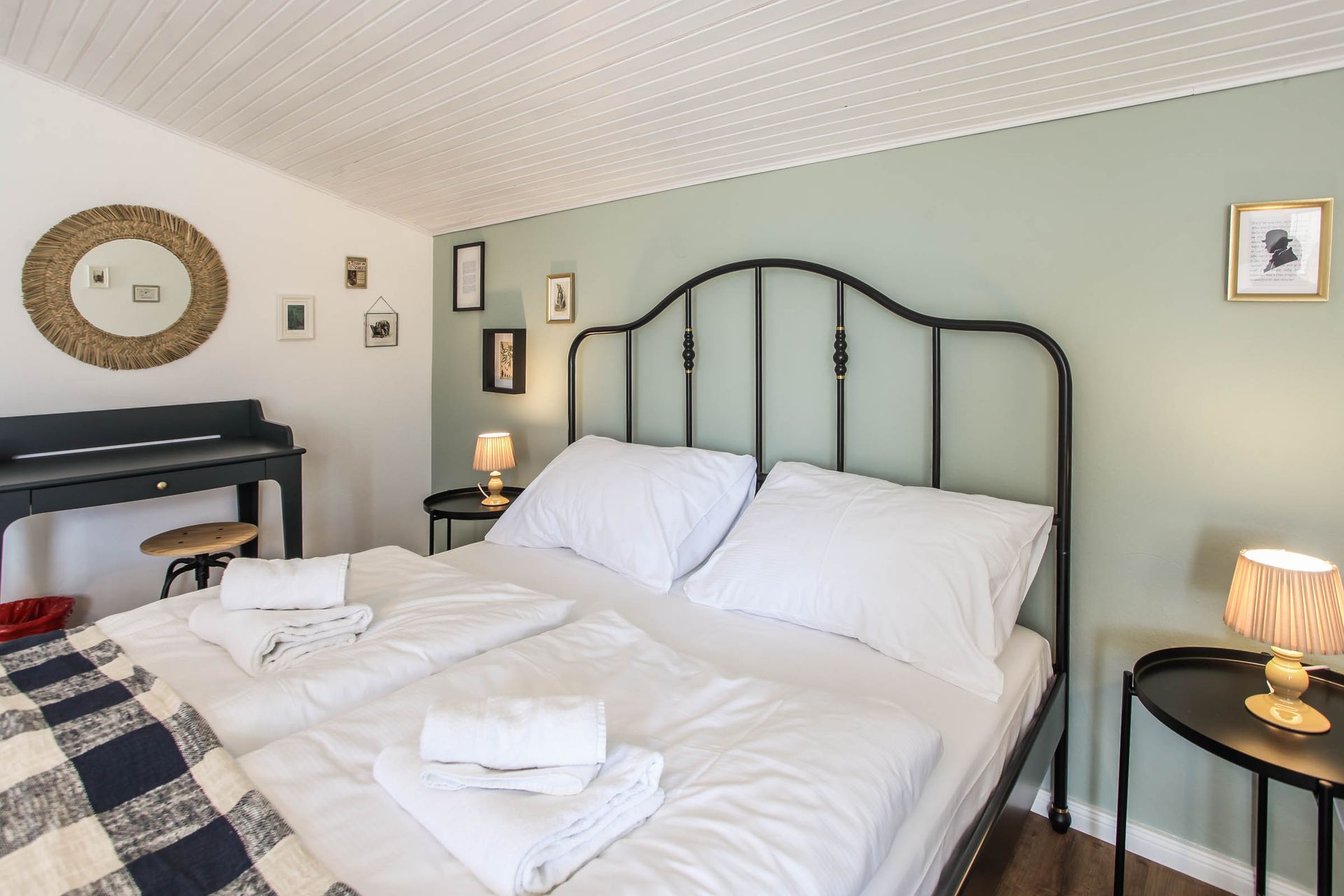 Cozy bedroom with a black metal bed, white bedding, and soft lamps on side tables