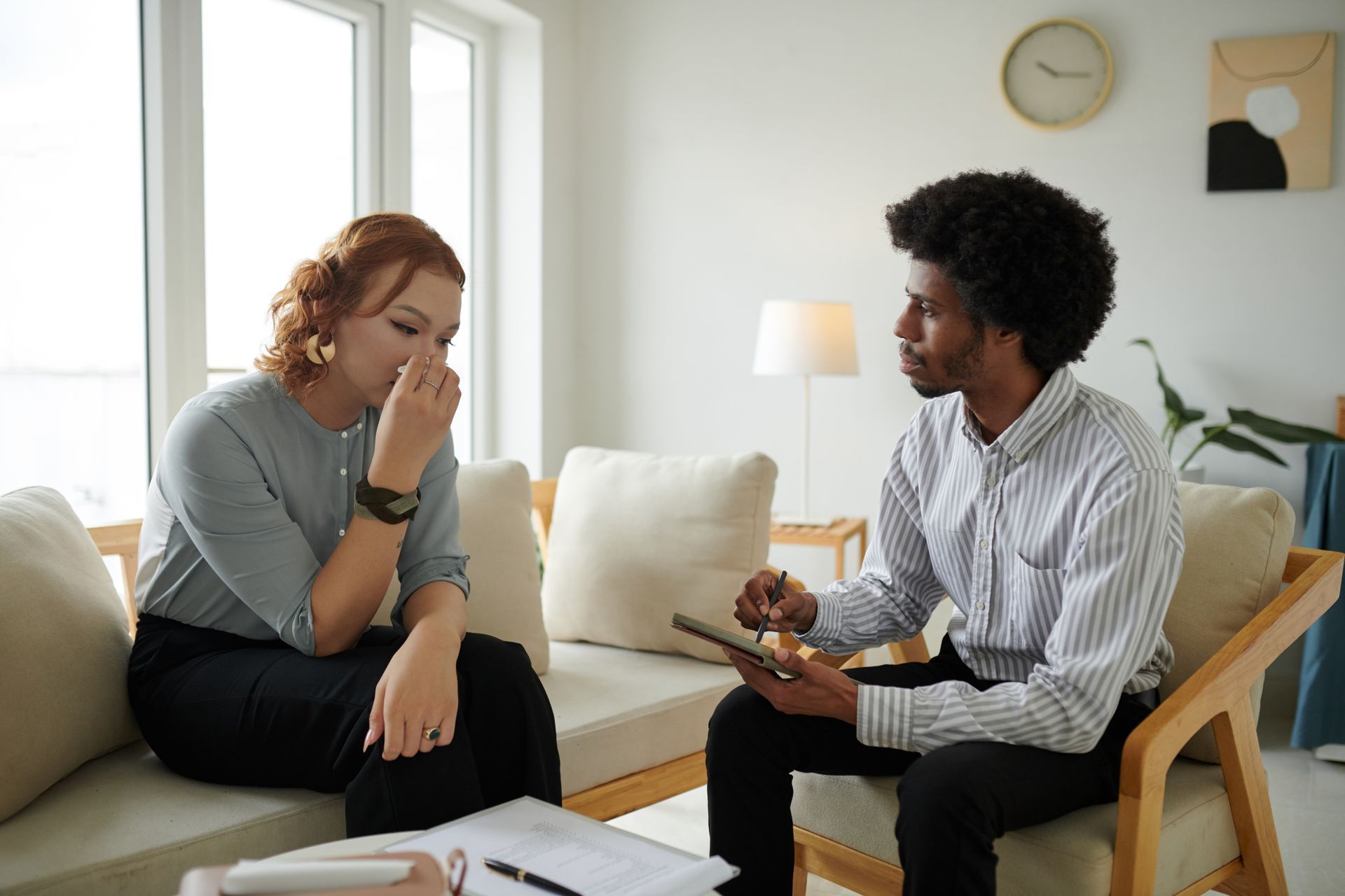 Woman processing emotional distress during a trauma-based therapy session with a counselor. Woman processing emotional distress during a trauma-based therapy session with a counselor.