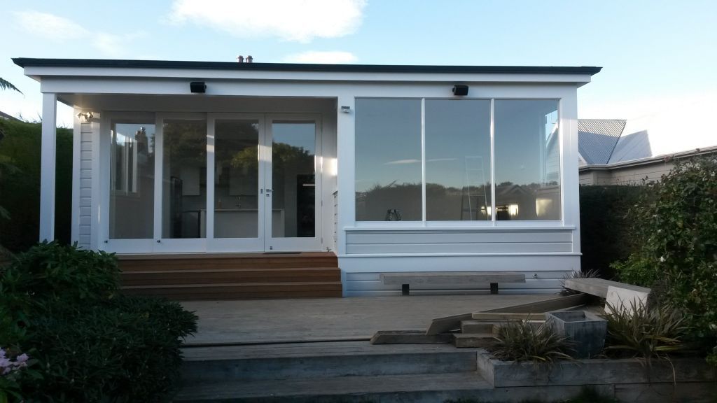 A small white house with a lot of windows