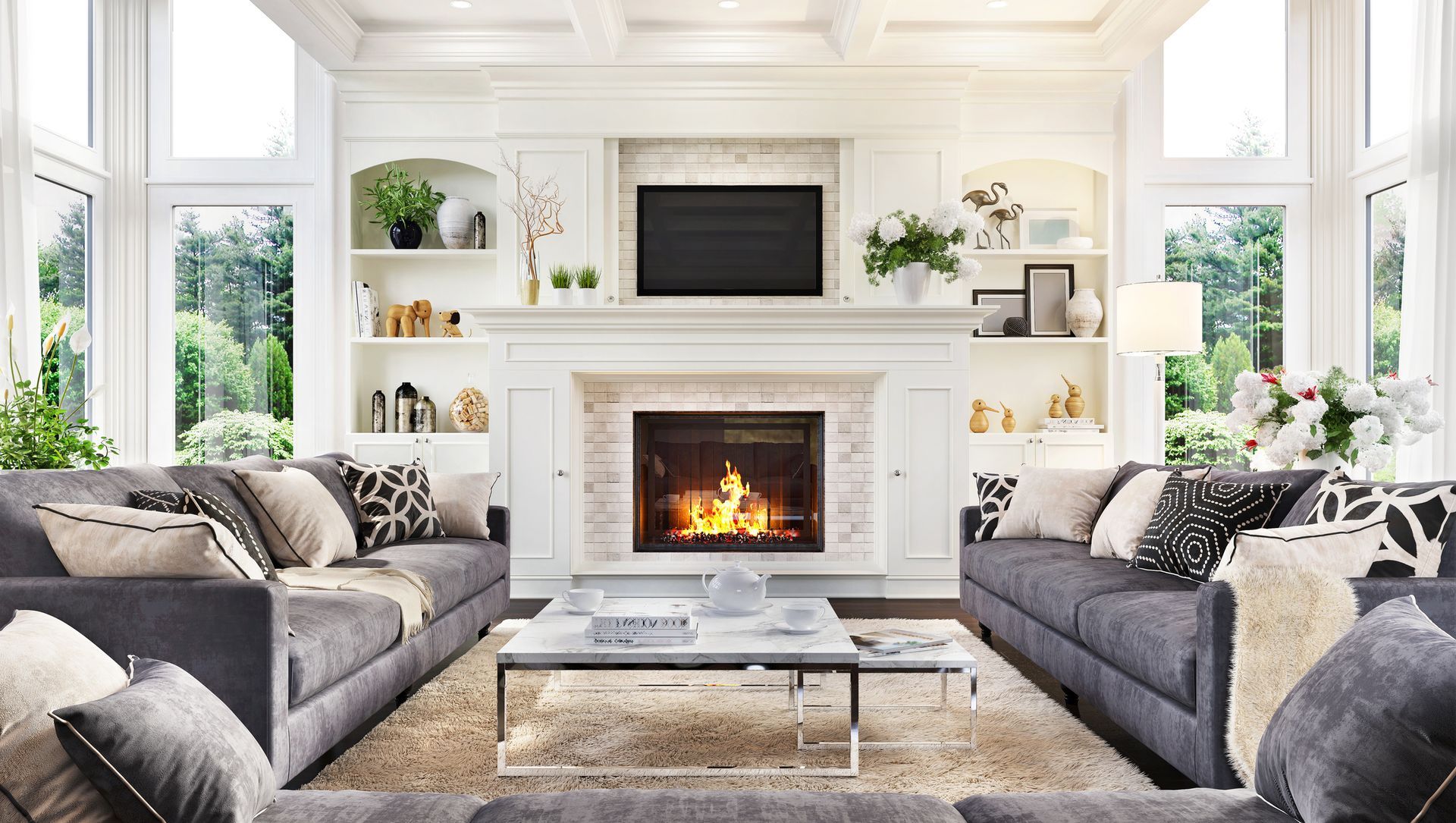 A living room with two couches , a fireplace and a flat screen tv.