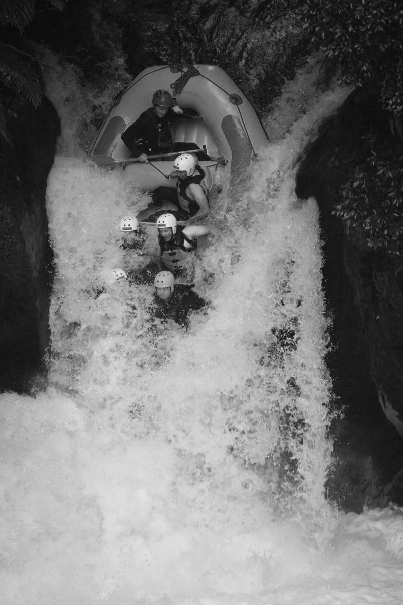 People in a raft going over a waterfall