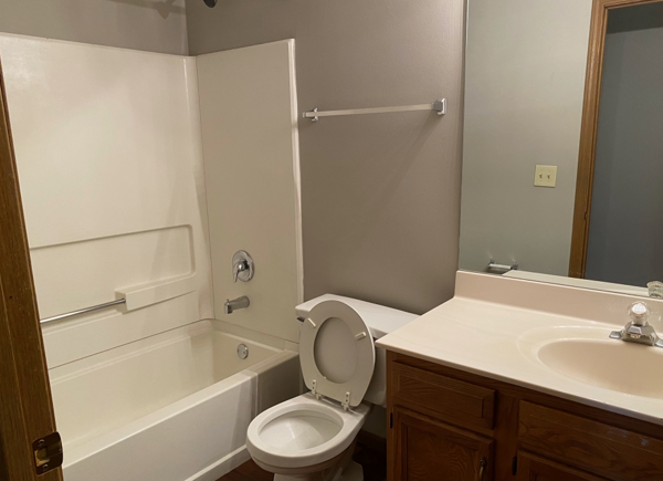 A bathroom with a toilet , sink and bathtub.
