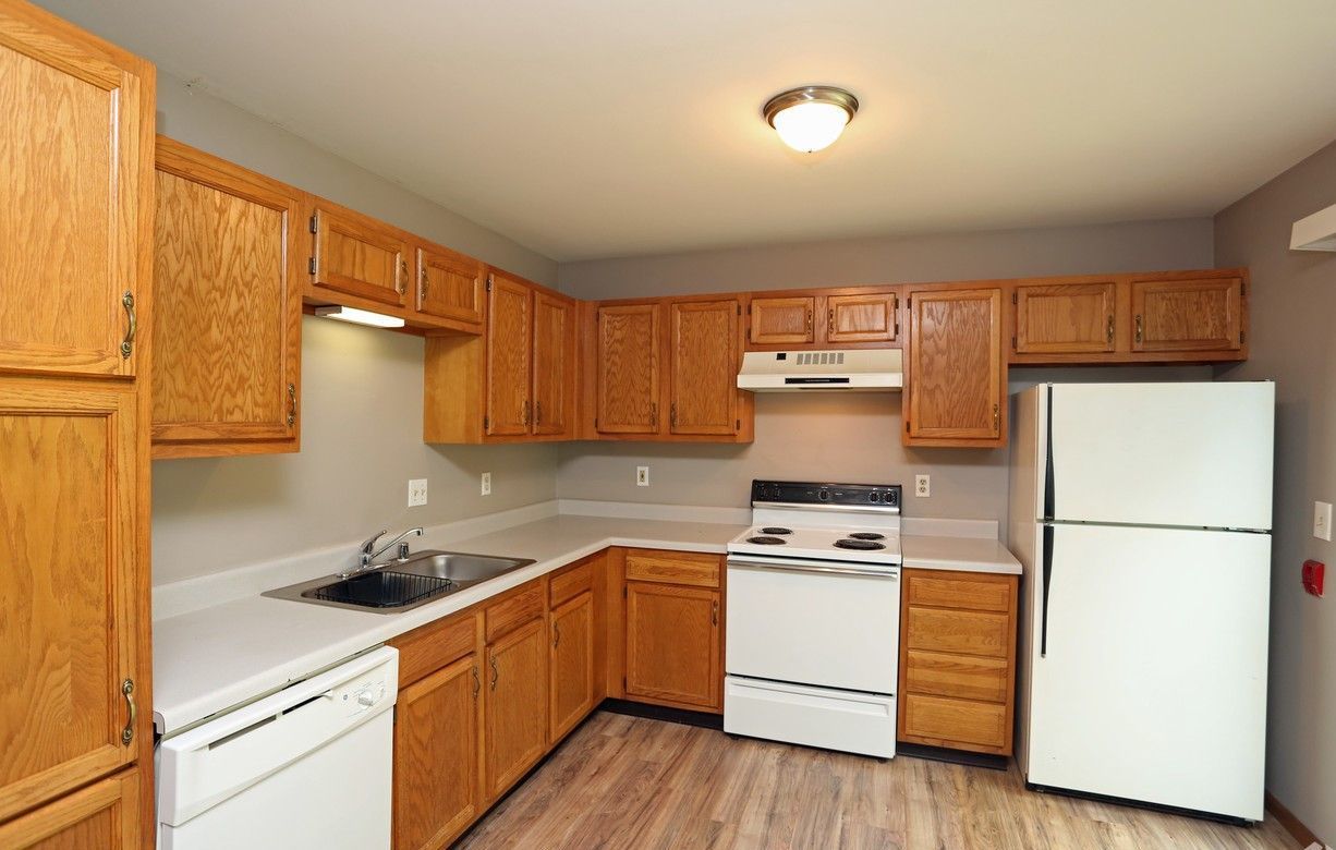 A kitchen with wooden cabinets and a white refrigerator