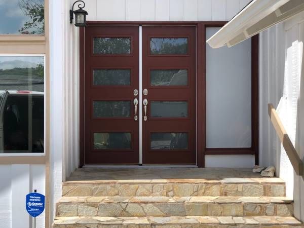 The front door of a house with stairs leading up to it.