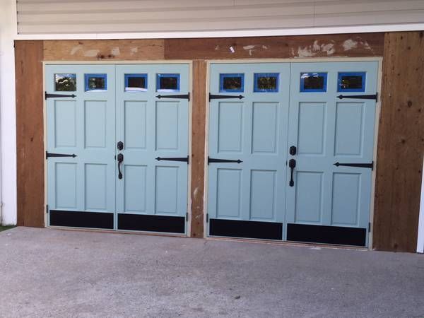 A pair of light blue garage doors with black handles