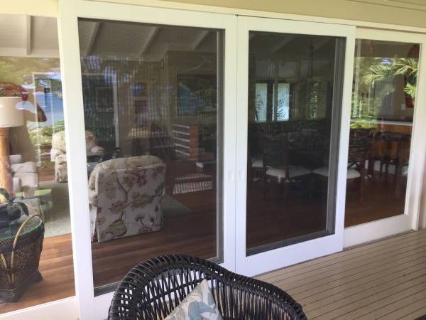 A living room with sliding glass doors and a wicker chair.