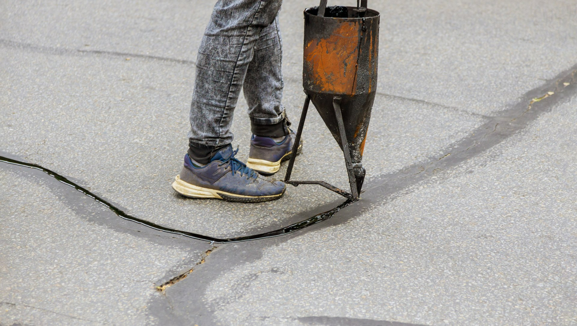 A worked filling in asphalt cracks