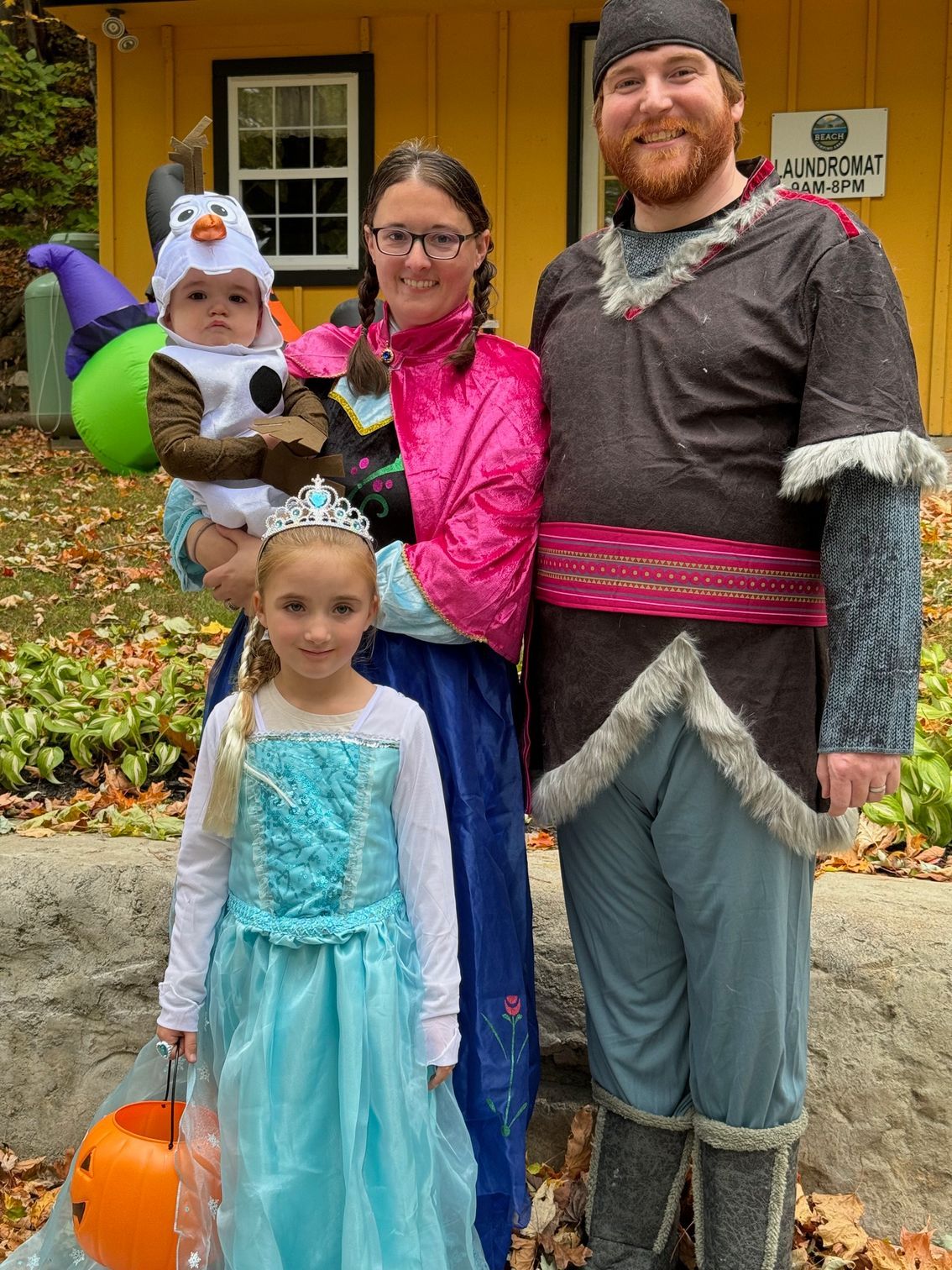 A family dressed in costumes for halloween is posing for a picture.