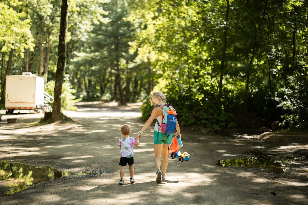 mother and son holding hands walking on gravel path