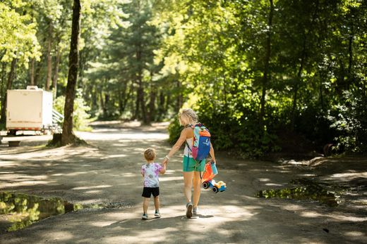 mother and son holding hands walking on gravel path