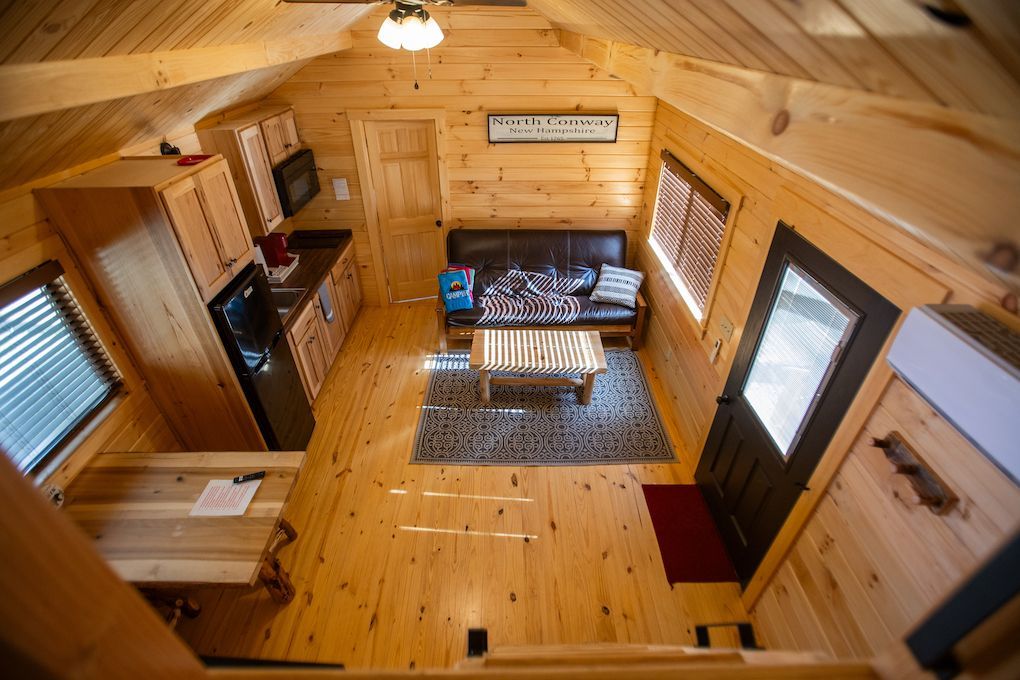 An aerial view of a wooden cabin with a living room and kitchen