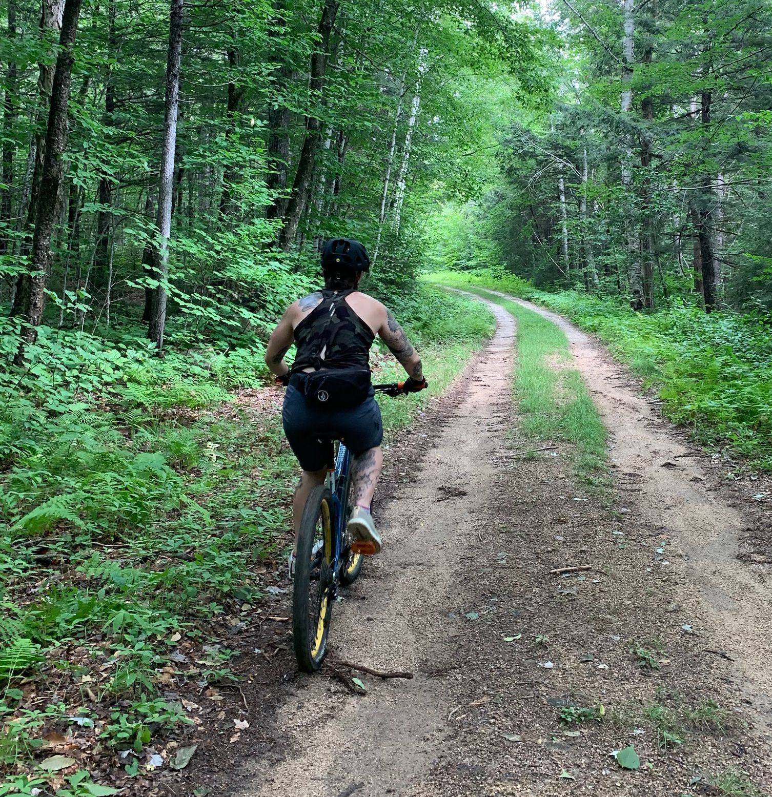 girl riding a bike on dirt road.