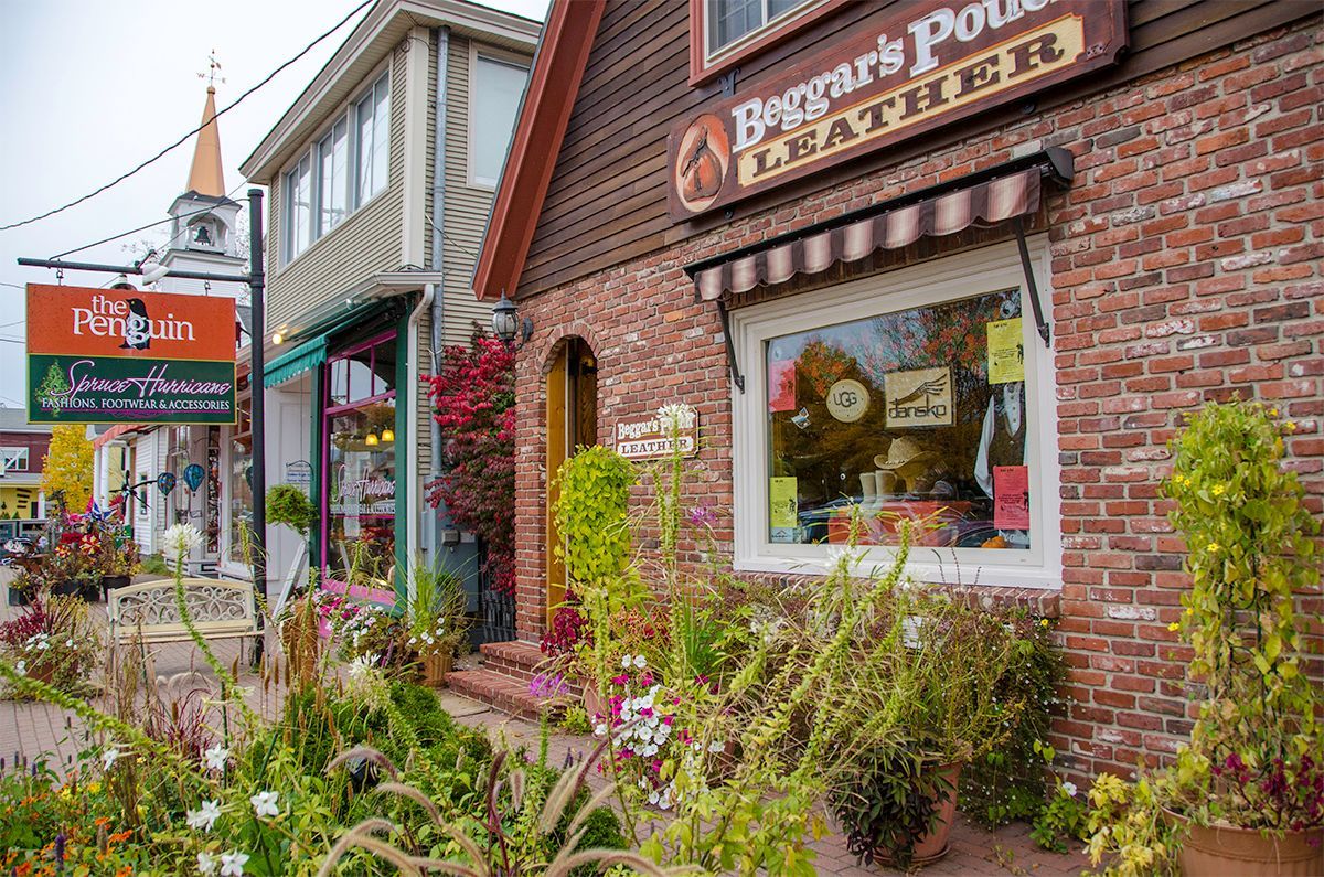 A brick building with a sign that says ' penguin 's point leather ' on it.