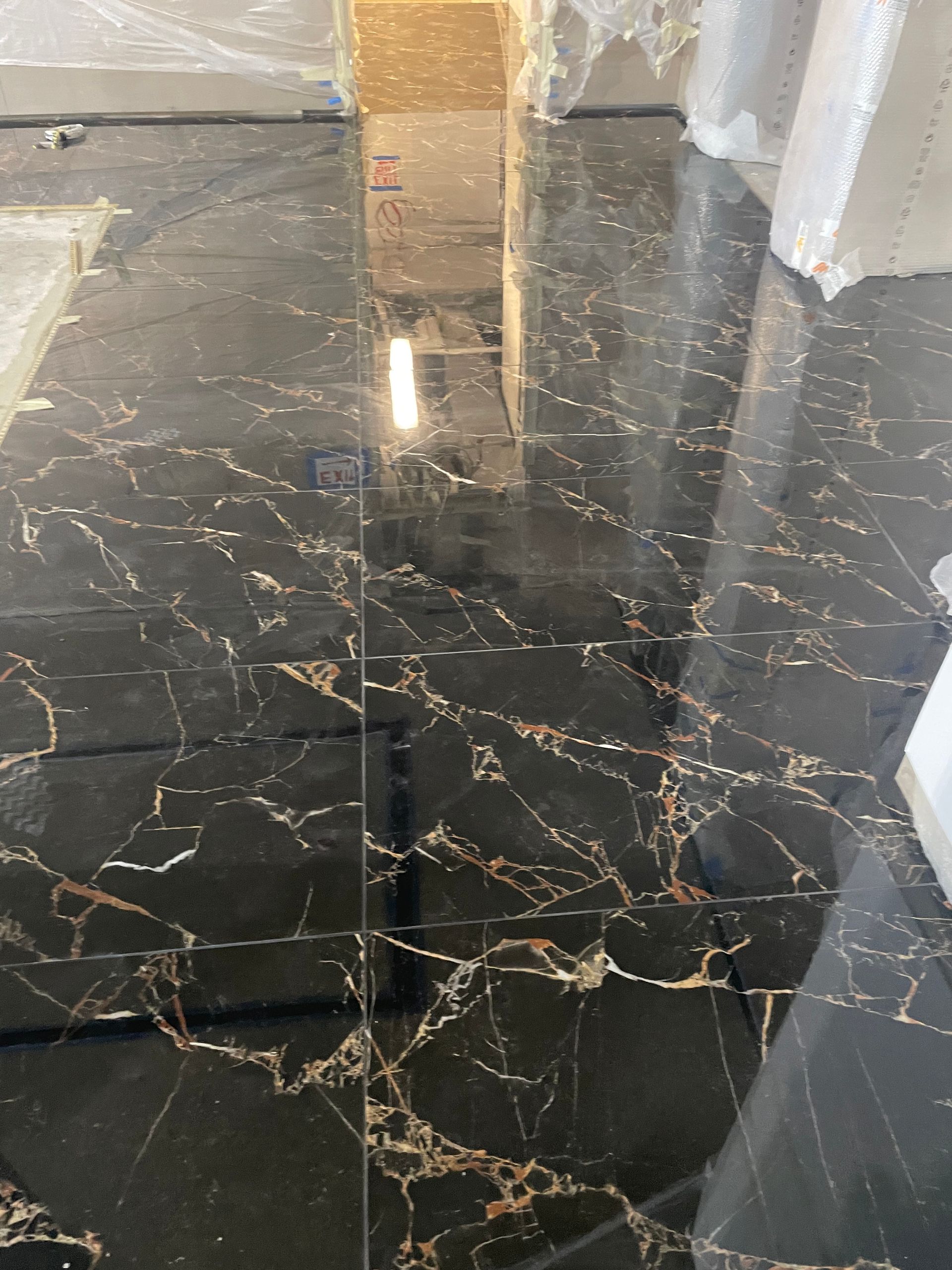 A black marble tile floor with a reflection of a building in it in East Brunswick, NJ.